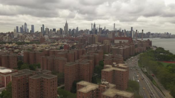 AERIAL: Vuelo sobre autopista con tráfico de coches, Skyline de la ciudad de Nueva York con cielo nublado — Vídeos de Stock