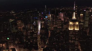 Gökyüzündeki ikonik Empire State Binası gece yarısı Manhattan, New York 'taki paralel caddeleri ve kavşakları aydınlattı.