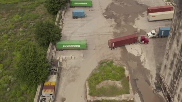 AERIAL: Siguiendo el camión de carga con carga pesada en los muelles de la ciudad de Nueva York Día gris nublado — Vídeo de stock