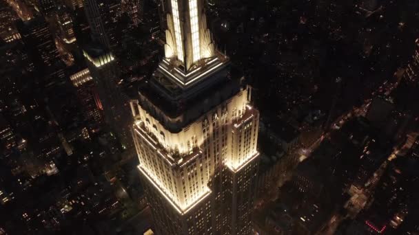 AERIAL: Epic close close close close close close heli shot of empire state bulding above lit up parallel avenues and junctions residential conapartments and office buildings in Midtown Manhattan, New York City at night — 图库视频影像