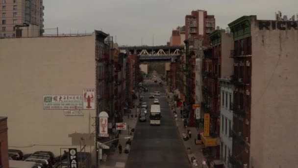 AERIAL: Niski lot przez Chinatown, ulica Nowego Jorku z chińskimi literami azjatyckimi w kierunku mostu — Wideo stockowe