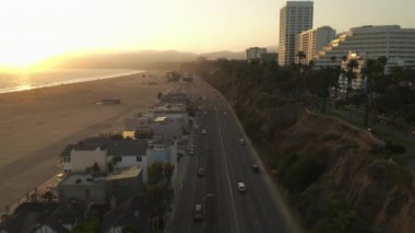 Los Angeles, Santa Monica İskelesi 'nin yanındaki Pasifik Sahil Otobanı manzaralı gün batımı dalgalarında hafif trafik ve okyanus manzaralı. 