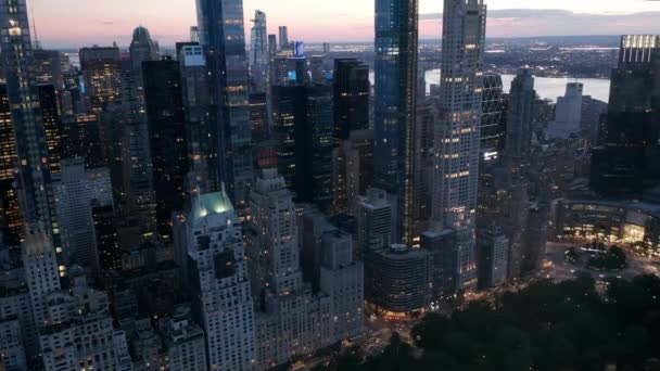 AERIAL: Manhattan Skyline på natten med blinkande stadsljus i New York City på Central Park — Stockvideo