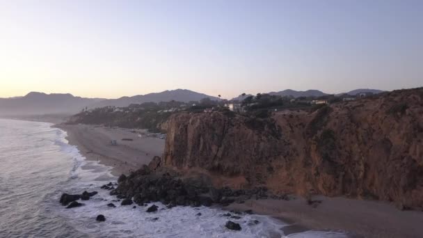 AERIAL: lot nad Malibu, Kalifornia widok na plażę Shore Line Paficic ocean o zachodzie słońca z urwiskiem górskim — Wideo stockowe