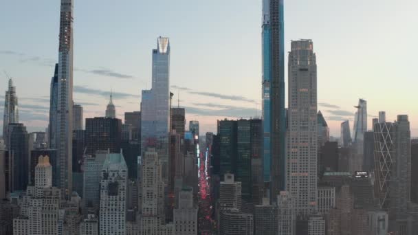AERIAL: Blick auf die 7th Avenue und den Times Square über den New Yorker Central Park bei Sonnenuntergang mit Lichtern der Stadt — Stockvideo