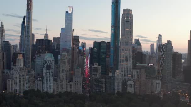 AERIAL: Pohled na 7th Avenue Traffic a Times Square na New York City Central Park při západu slunce se světly City — Stock video