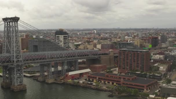 AERIAL: Flyg över Williamsburg Bridge Brooklyn sida med bil trafik och gator på molnig dag — Stockvideo