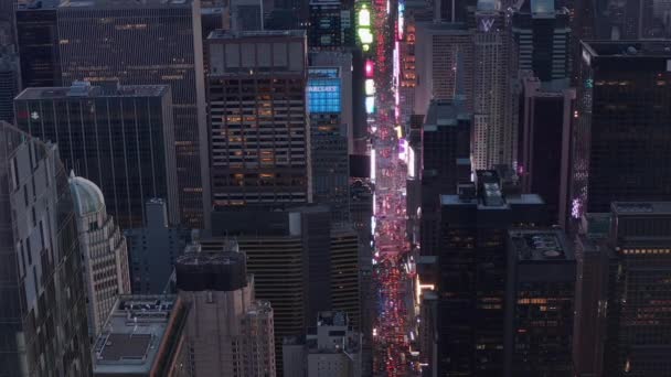 AERIAL: Närbild av nya Manhattan Skyskrapa med Times Square och stadsljus glöder i ryggen, Vacker — Stockvideo
