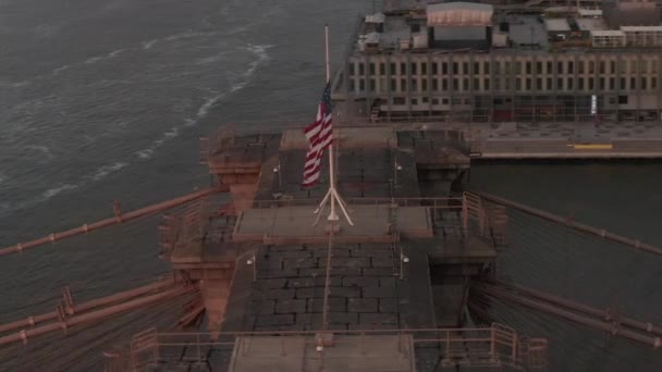 Close-up cirkelvlucht over Brooklyn Bridge met Amerikaanse vlag en mistige Manhattan New York City Skyline — Stockvideo
