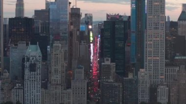 Sunset 'teki New York City Central Park' taki trafik ve Times Meydanı 'nın üzerinde şehir ışıklarıyla