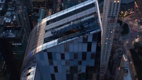 AERIAL: Close Up cirklar runt nya Manhattan Skyskrapa vid solnedgången med trafikljus — Stockvideo