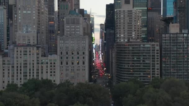 AERIAL:シティライト付きサンセットのニューヨークシティセントラルパークの7番街の交通とタイムズスクエアの眺め — ストック動画