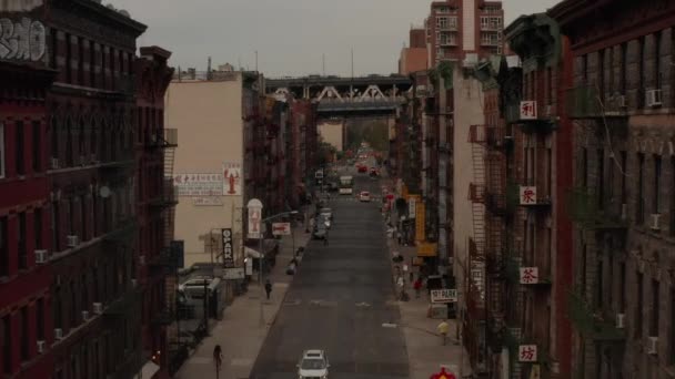 AERIAL: Niski lot przez Chinatown, ulica Nowego Jorku z chińskimi literami azjatyckimi w kierunku mostu — Wideo stockowe