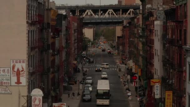 AERIAL: Vôo baixo através de Chinatown, rua de Nova York com letras asiáticas chinesas em direção à ponte — Vídeo de Stock