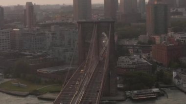 Brooklyn Köprüsü üzerinde sabah güneşiyle Brooklyn 'e doğru hareket eden bir araba trafiği var. 