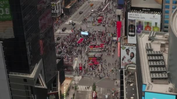 AERIAL: Look over Times Square heart of New York City at Daylight with crowd of people and heavy car traffic advertisements and police — Stock Video