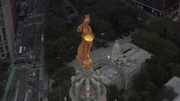 AERIAL: Estatua dorada circundante en la ciudad de Nueva York con tráfico por carretera y ciudad ocupada — Vídeos de Stock