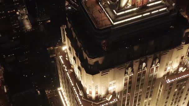 AERIAL: Impresionante círculo sobre el icónico Empire State Building arriba iluminado avenidas paralelas y uniones condominios residenciales y edificios de oficinas en Midtown Manhattan, Nueva York por la noche — Vídeos de Stock