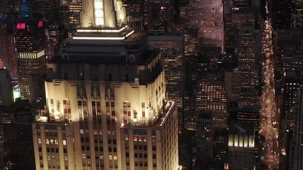 AERIAL: Volar por encima iluminó avenidas y cruces paralelas, condominios residenciales y edificios de oficinas en Midtown Manhattan, Nueva York por la noche. Infraestructura vial en las metrópolis — Vídeos de Stock