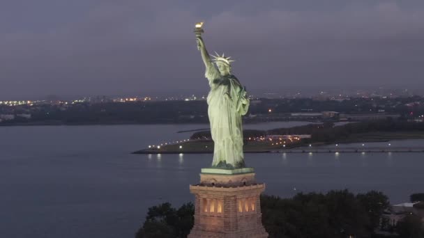 AERIAL: Circling Statue of Liberty beautiful illuminated in early morning light New York City — стоковое видео