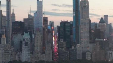 Sunset 'teki New York City Central Park' taki trafik ve Times Meydanı 'nın üzerinde şehir ışıklarıyla