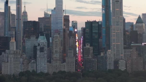 AERIAL: Zicht op 7th Avenue Traffic en Times Square boven New York City Central Park bij zonsondergang met City lights — Stockvideo