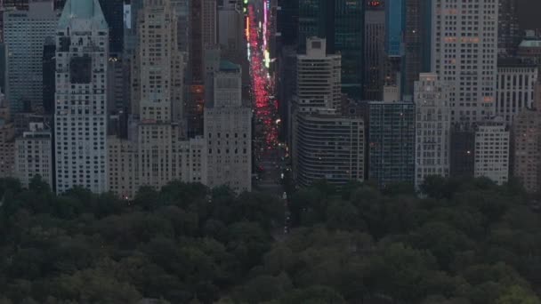 AERIAL: Vista del tráfico de la 7ª Avenida y Times Square sobre el Central Park de Nueva York al atardecer con luces de la ciudad — Vídeo de stock
