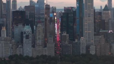 Sunset 'teki New York City Central Park' taki trafik ve Times Meydanı 'nın üzerinde şehir ışıklarıyla