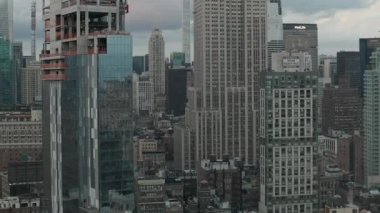 Manhattan 'daki Empire State binasında bulutlu bir günde kalabalık bir şehirde tırpancılarla uçmak. 