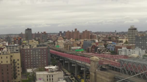 AERIAL: vlucht over Williamsburg Bridge Brooklyn kant met autoverkeer en straten op bewolkte dag — Stockvideo