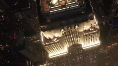 Gökyüzündeki ikonik Empire State Binası üzerinde nefes kesici bir uçuş paralel caddeler ve kavşakları aydınlattı Manhattan, New York 'ta gece yarısı konut ve ofis binaları.