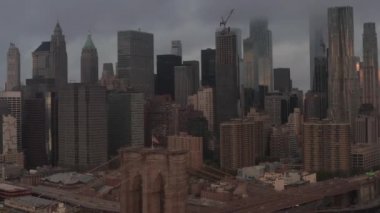 Brooklyn Köprüsü üzerinden sisli Manhattan City Skyline 'a doğru uçuş. 