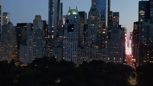 AERIAL: Manhattan Skyline på natten med blinkande stadsljus i New York City på Central Park — Stockvideo