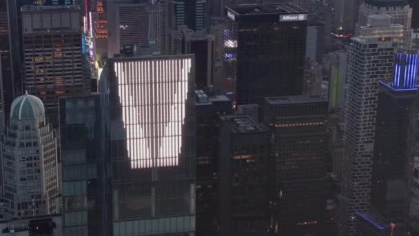 AERIAL: epicki widok na ogromny enourmus nowy wieżowiec na Manhattanie o zachodzie słońca ze światłami i tłem Nowego Jorku — Wideo stockowe