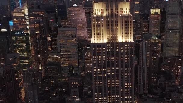 AERIAL:忙しい都市のスクラッパーに囲まれた夜の美しいマンハッタンを見下ろす — ストック動画