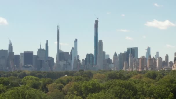 AERIAL: Bela vista do Central Park e Manhattan Skyline em segundo plano no dia ensolarado de verão — Vídeo de Stock