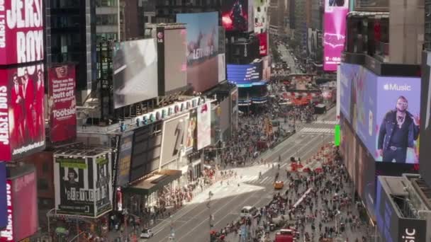 AERIAL: Närbild flygning över Times Square hjärtat av New York City i dagsljus med massor av människor och tung biltrafik — Stockvideo