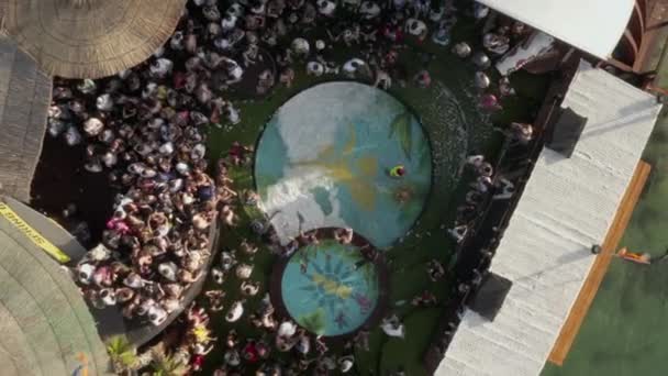 AERIAL: Close up of People dancing party with ocean in Novalia, in sunny weather and flags, Palm trees and Pools — 图库视频影像
