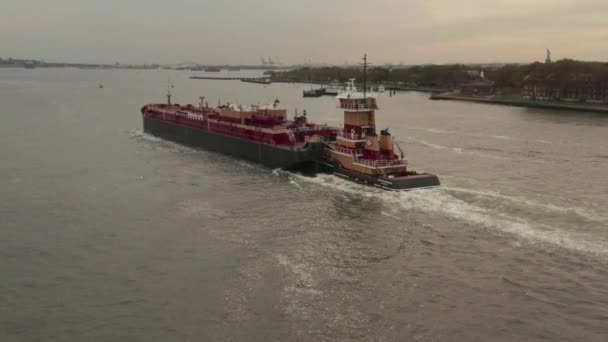 AERIAL: Siguiendo el gran buque de carga rojo en los muelles de la ciudad de Nueva York en un día nublado — Vídeos de Stock