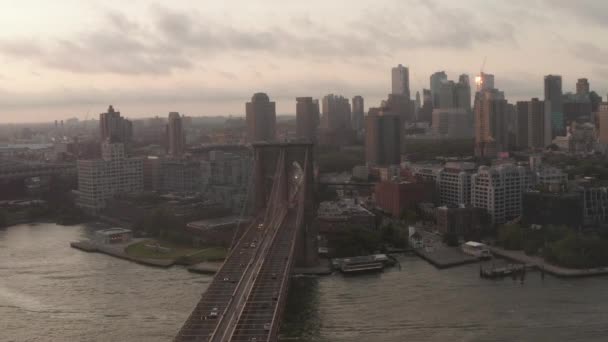 AERIAL: Flug über Brooklyn Bridge mit fahrendem Autoverkehr Sonnenaufgang Morgenlicht in Richtung brooklyn — Stockvideo