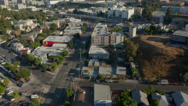 AERIAL: Létání směrem do centra Los Angeles, Kalifornie Skyline s pohledem na domy a pouliční provoz na krásné modré obloze a slunečný den — Stock video