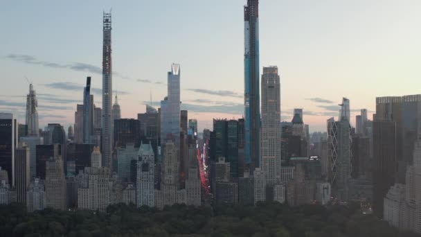 AERIAL: Vista da 7th Avenue Traffic e Times Square sobre o New York City Central Park ao pôr do sol com luzes da cidade — Vídeo de Stock