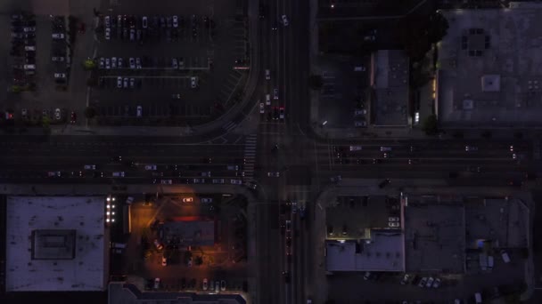 AERIAL: Birds eye view of Culver City, Los Angeles, California traffic夕暮れ時の交差点車の通行と駐車場 — ストック動画