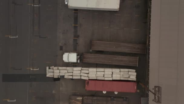 AÉRIAL : Birdseye Vue de la zone de chargement des camions de fret avec des caisses et des conteneurs — Video