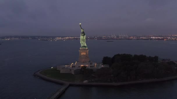 AERIAL: Circle Statue of Liberty prachtig verlicht in de vroege ochtend licht New York City — Stockvideo