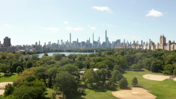 AERIAL: Schöner Blick auf den Central Park und die Skyline von Manhattan im Hintergrund an einem sonnigen Sommertag — Stockvideo