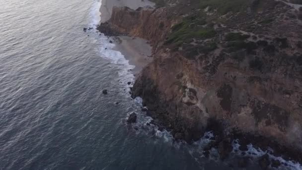 AERIAL: flyg över Malibu, Kalifornien utsikt över stranden Shore Line Paficic ocean at sunset with mountain cliff — Stockvideo