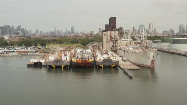 AERIAL: Över Rusty gamla lastfartyg och gamla Magasinet i Docks of New York City på en molnig grå dag — Stockvideo