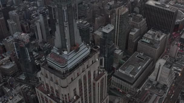 AERIAL: Vackra skott cirklar Empire State byggnaden i Manhattan omgiven av lie skrapor i upptagen stad på molnig dag — Stockvideo