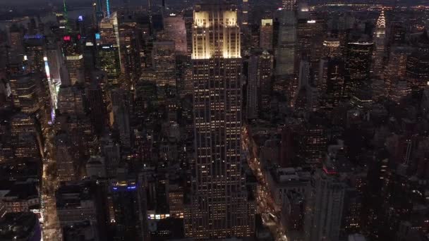 AERIAL: Titta ner på vackra Manhattan på natten omgiven av lie skrapor i upptagen stad i — Stockvideo